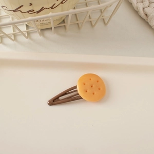 Detailed view of a cute biscuit hair clip with realistic cookie texture on a metal BB clip