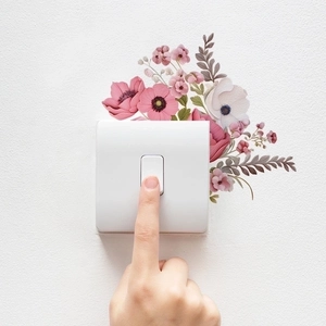 Pink floral switch sticker with green leaves applied on white wall socket panel