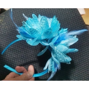 Close-up of blue mesh flower headband with feathers and sequins for party hair styling
