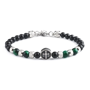 Macro view of beaded bracelet with black and green stones and silver cross charm