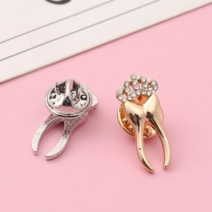 Detailed view of molar tooth brooches with sparkling rhinestones and butterfly clasp