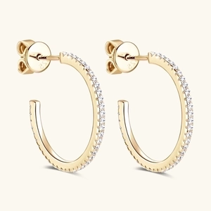 Macro detail of gold C-shaped S925 silver hoop earrings with shimmering pavé set zircons