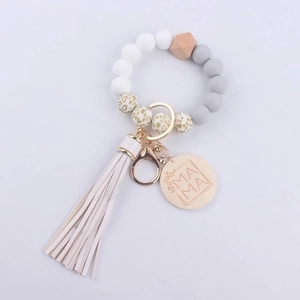 Detail of beaded keychain with leopard silicone beads, white tassel and MAMA engraved disc