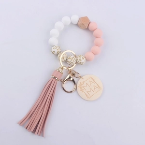 Close-up of silicone beads, pink tassel, and wooden MAMA tag on the wristlet keychain
