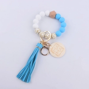 Close-up of silicone beaded keychain bracelet with MAMA wooden tag and blue tassel detail