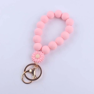 Pink silicone beaded wristlet keychain with daisy charm and golden metal lobster clasp
