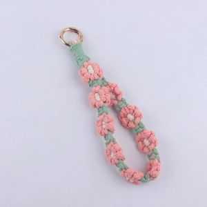 Detail view of pink and green hand-woven cotton daisy lanyard with golden ring