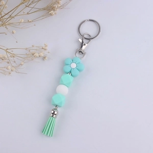 Detail of mint green flower silicone bead keychain with lobster clasp and soft tassel