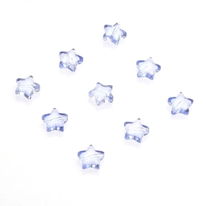Macro shot of 10mm transparent blue star-shaped glass charms with central hole for DIY