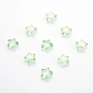 Macro detail of transparent green star-shaped glass beads for DIY jewelry making