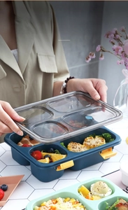 Detail of multi-compartment lunch box with secure yellow buckles and airtight vent lid