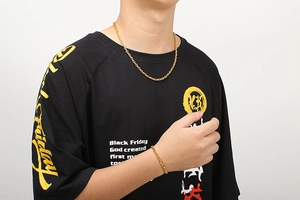 Goldenes Set aus Schweinenasen-Kette und Armband an einem männlichen Model auf weißem Grund