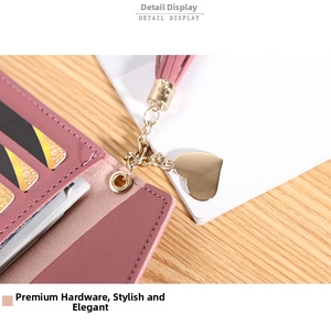 Detail view of pink leather wallet featuring gold heart pendant and multiple card slots