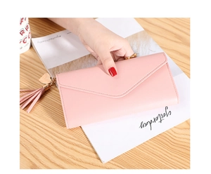 Detailed view of pink lychee grain leather wallet with heart pendant and long tassel charm