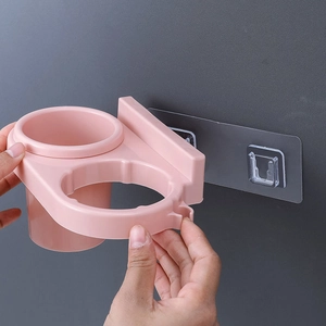 Pink wall-mounted hair dryer holder with two compartments and seamless adhesive sticker