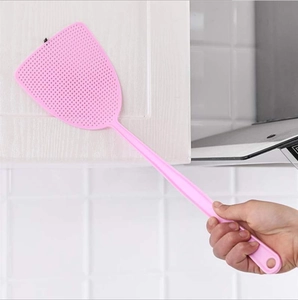 Pink plastic fly swatter with a long handle and mesh head for home pest control