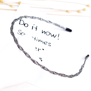 Detail shot of a slim silver woven texture headband with protective black end caps
