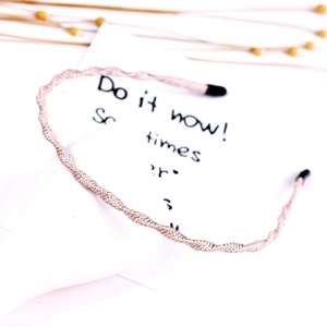 Detail of pink gold wavy metal headband with glitter finish on aesthetic white card
