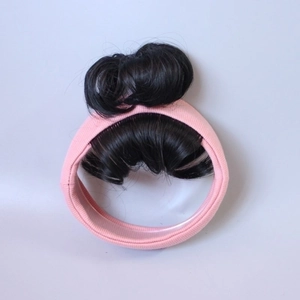 Pink elastic baby headband featuring two cute black synthetic hair buns in a top knot style