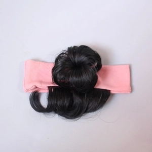 Detail of synthetic black hair bun and soft pink knitted headband for infants and girls