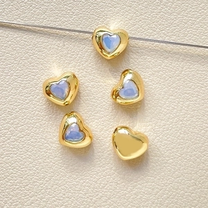 Macro shot of 18k gold-plated heart beads with blue zircon for DIY jewelry making
