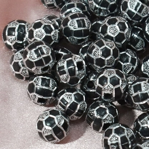 Detailed view of silver and black football pattern acrylic beads for jewelry making