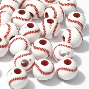 Macro shot of acrylic baseball beads with red stitching and center holes for jewelry