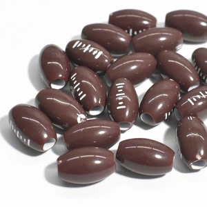 Macro shot of brown rugby-shaped acrylic loose beads with white stitching for DIY crafts