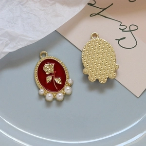 Detail of red enamel rose pendant with pearls and textured gold back for DIY jewelry