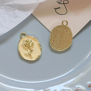Detail of vintage gold alloy rose charms with pearlescent finish for DIY jewelry