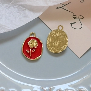 Close-up of red enamel rose pendant with gold relief and pearl accent for DIY jewelry