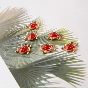 Red beetle alloy charms with gold accents on a leaf for DIY jewelry making