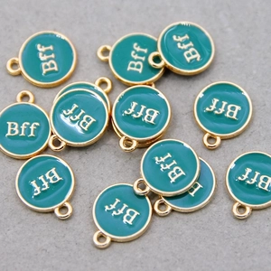 Detailed view of round green enamel BFF charms with gold plated borders for DIY jewelry