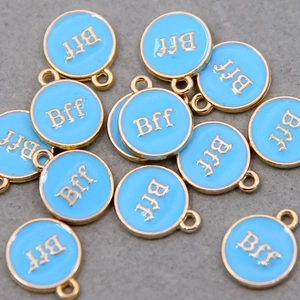 Detail of round light blue enamel BFF charms with gold edges for DIY jewelry making