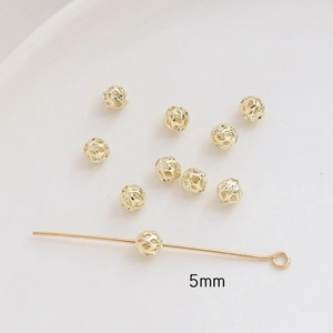 Close-up of 5mm hollow gold-plated copper beads and headpins for DIY jewelry making
