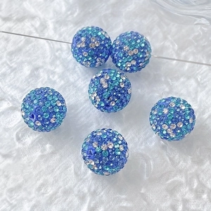Detailed macro view of vibrant blue and silver gradient rhinestone disco ball beads