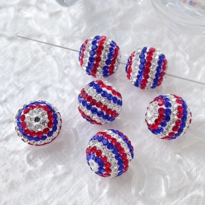 Macro detail of six sparkling red white and blue gradient crystal rhinestone ball beads