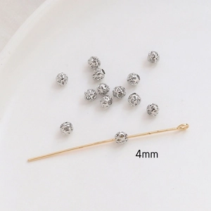 Detailed view of 4mm hollow spherical silver beads and gold pin for DIY jewelry making
