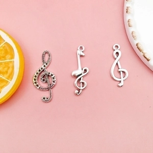 Three silver music note pendants featuring treble clef and eighth note for DIY jewelry