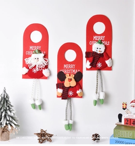Three festive Christmas door hangers with Santa, Elk, and Snowman on a white wall