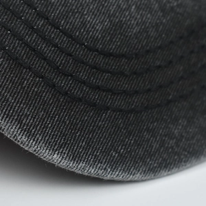 Macro detail of dark grey washed cotton baseball cap brim with triple stitched seams