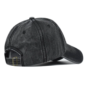 Detail of adjustable metal buckle and vintage washed denim texture on a baseball cap