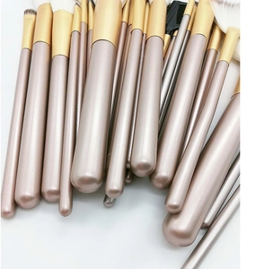 Detailed view of champagne gold makeup brush handles with soft synthetic bristles