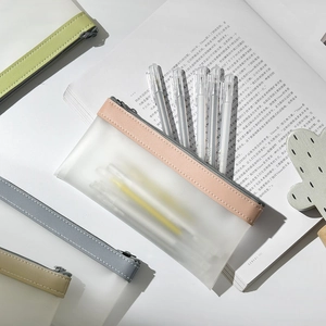 Transparent matte pencil case with pink zipper on white desk with assorted colors