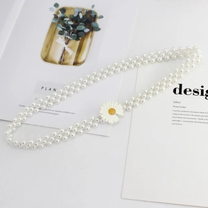 Détail de la ceinture en perles double rang avec boucle fleur de marguerite pour robe