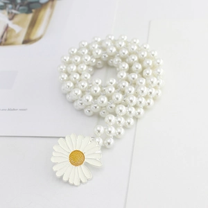 Détail de la chaîne de taille en perles blanches avec pendentif marguerite émaillée