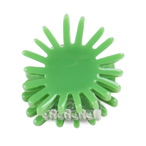 Detail of a bright green sun-shaped mini hair claw clip with glossy finish and metal spring