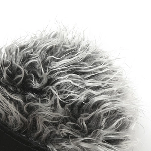 Détail macro montrant la texture des cheveux bouclés gris argenté sur un bonnet rétro