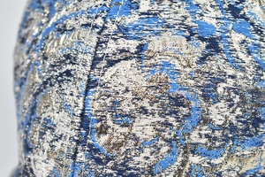 Détail de casquette hip hop montrant le tissu jacquard bleu argenté et les coutures