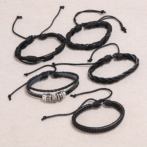 Five-piece black braided leather bracelet set for men featuring a metal skull charm detail